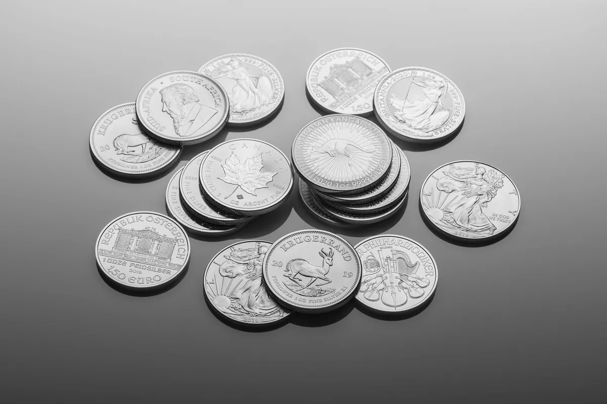 Close-up of shiny silver bullion coins with detailed designs, highlighting the importance of quality in purchases.